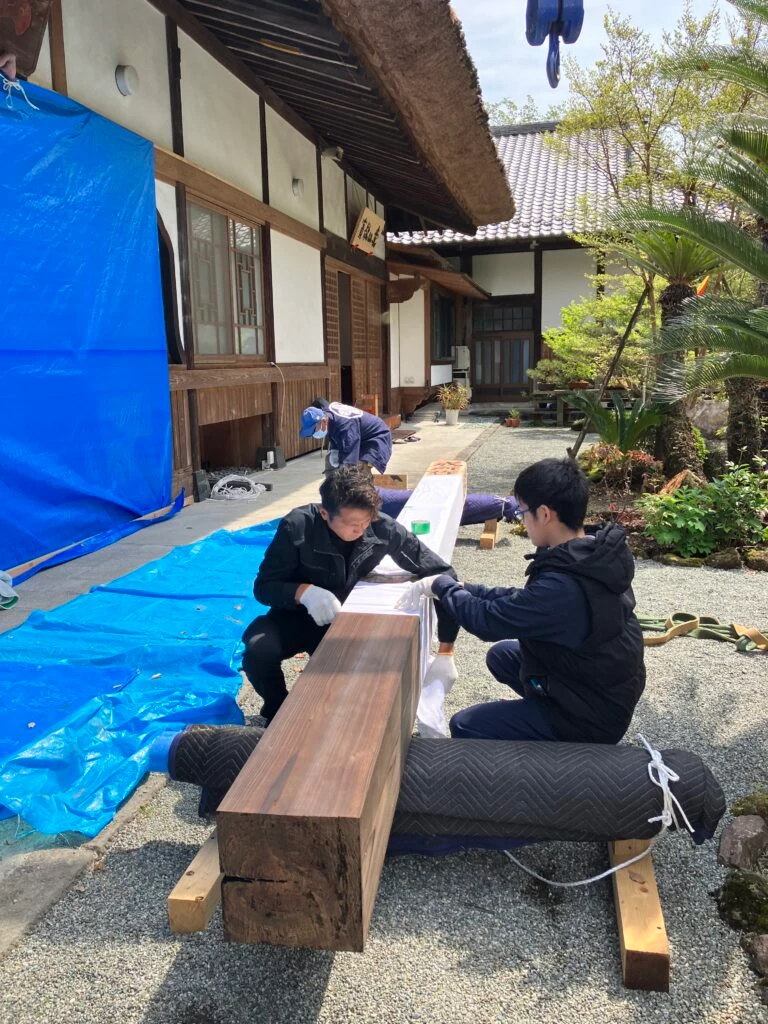 寺院の軒前で角材を加工する職人たち
